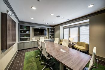 A conference room with a table and chairs and a television